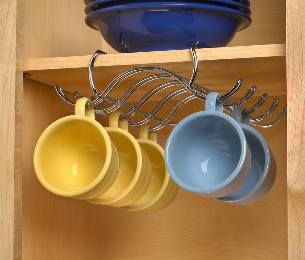 آویز فنجان داخل کابینتی که برای چیدمان فنجان های دسته دار آبی و زرد رنگ در قفسه کابینت استفاده شده است